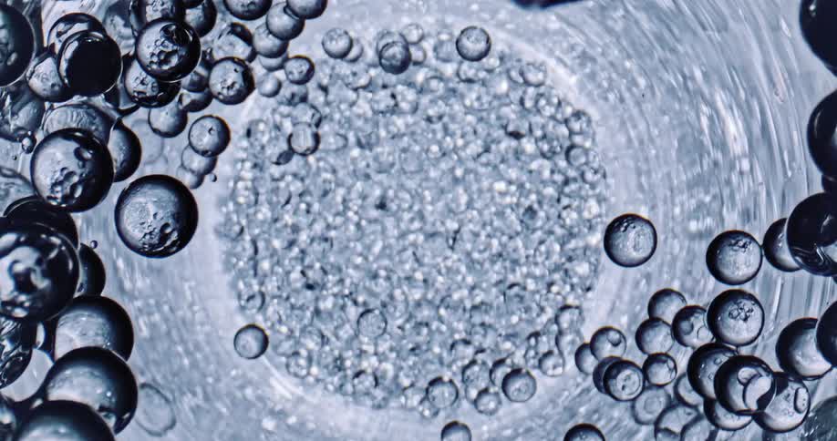 Many spheres are rotating around a vortex as they fall into the depths of the tunnel