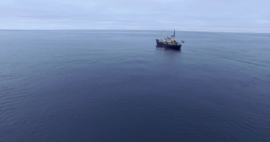 A boat is sailing in the ocean on a cloudy day