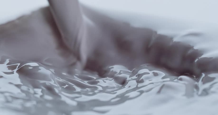Creamy liquid pours down causing surface to churn