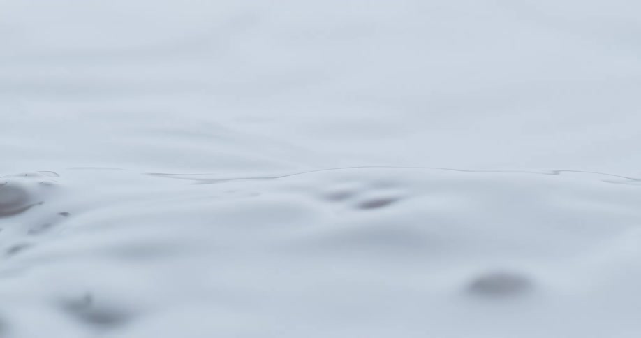 Ripples form and spread across the surface of a viscous liquid