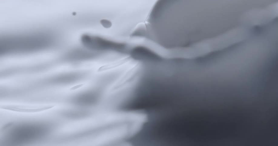 A white drop falls in the liquid