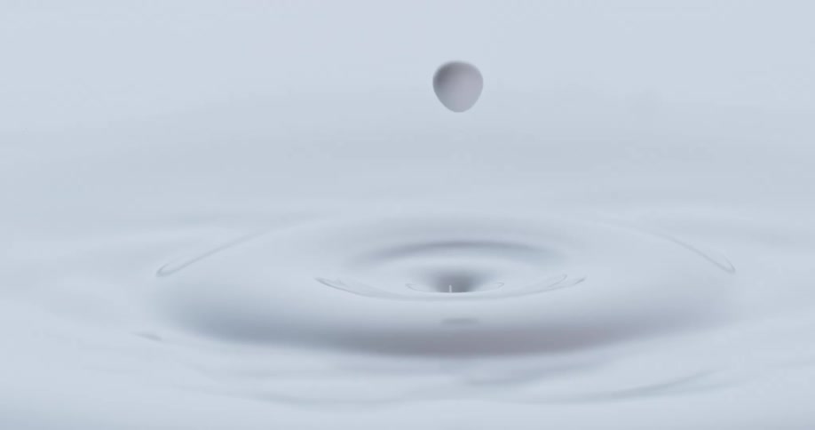 An orb falls into a white liquid and creates a circular ring splashing upwards and splashes back up from the center and more orbs fall in