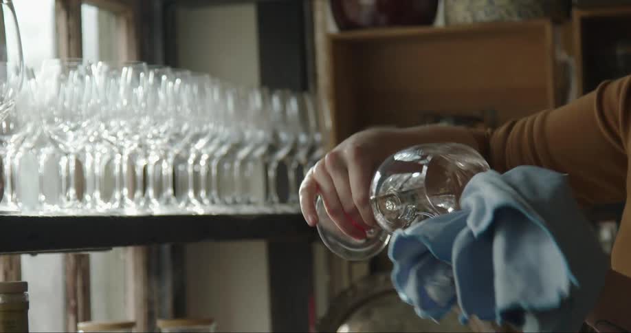 A woman is cleaning a wine glass