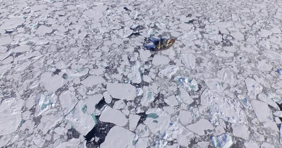 A boat is in the water filled with ice