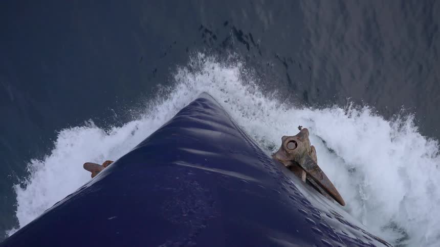 The hull of a moving is breaking through the water