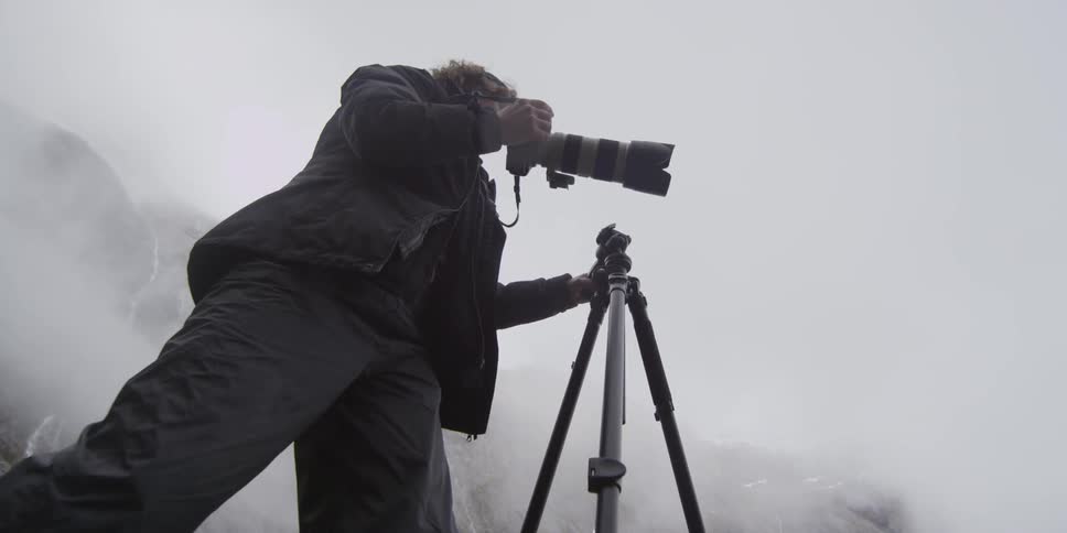 A woman is placing a camera on a tripod