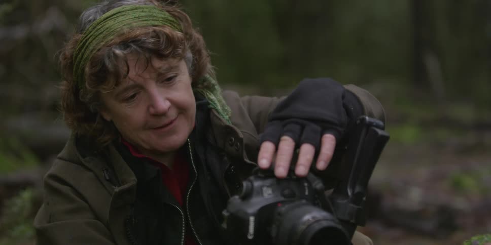 A woman adjusts her camera