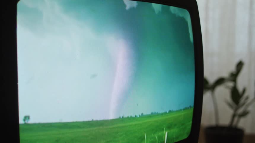 Vintage television screen with a tornado on it up close