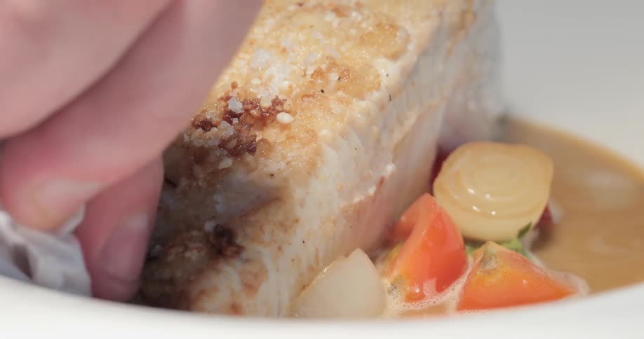 A person wipes the side of a dish with a tissue