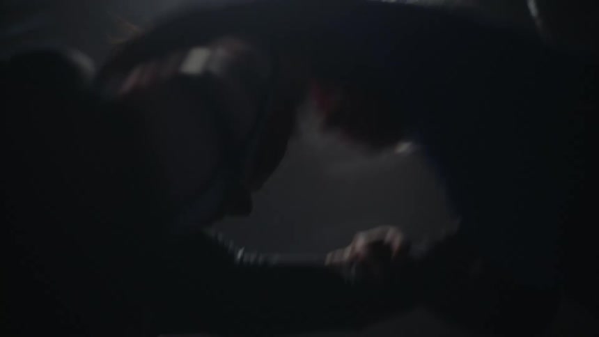 Two women grapple with each other as they spar in a gym