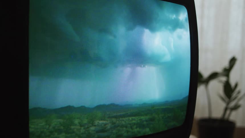 Video on television shows lighting storm moving across landscape