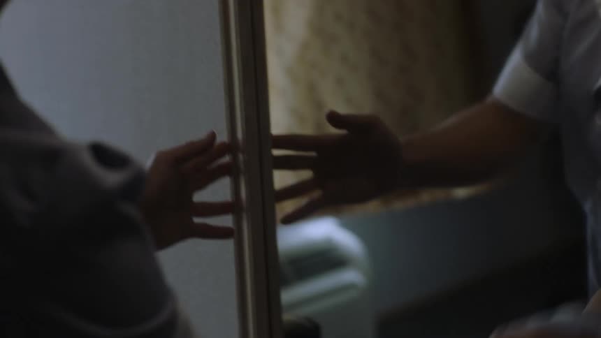 A cleaning lady wipes the mirror