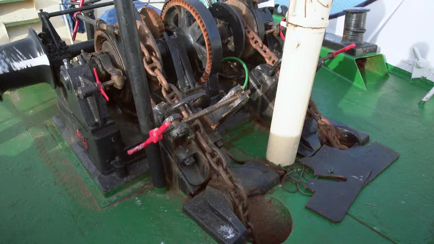 A big iron chain is pulled through a pulley system