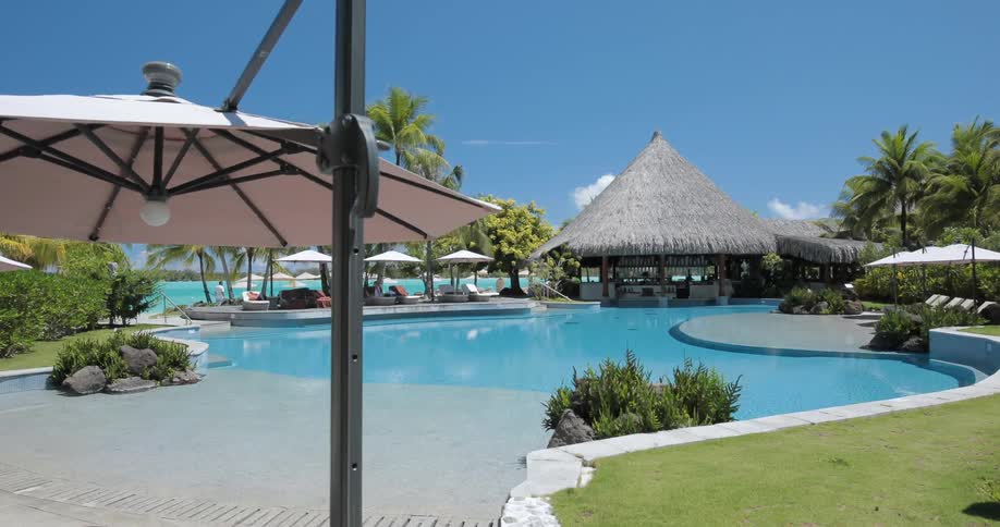 A resort has a large pool with huts