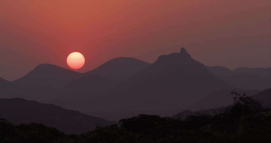 The sky is red as the sun sets