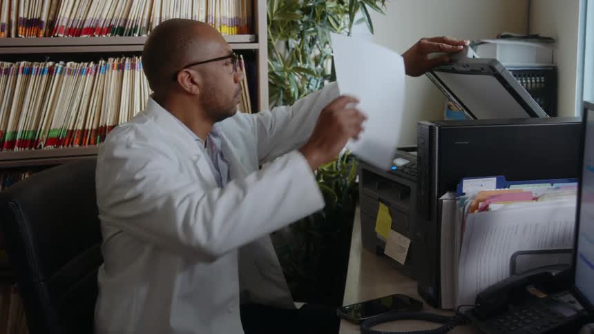 A man is printing documents in his office