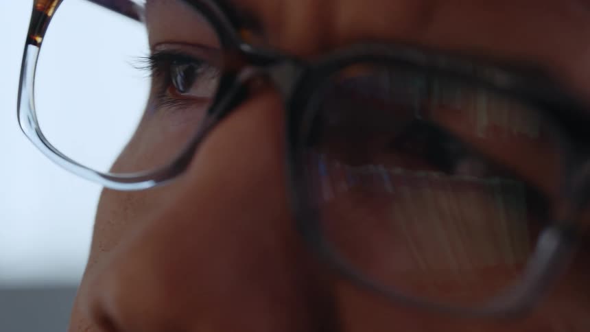 An extreme close up of a mans face wearing glasses