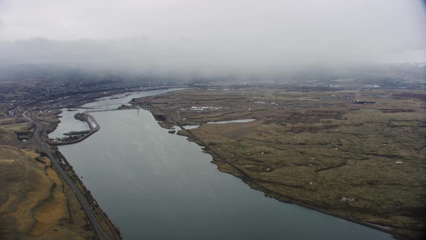 Aerial view of a river covered in fog is displayed