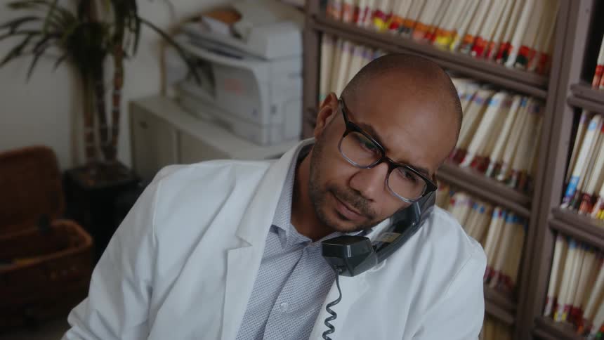 A man is talking on the phone in the office
