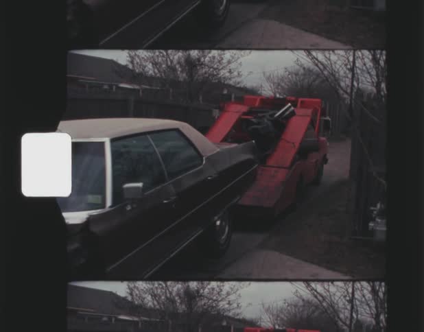 A tow truck pulls a car down the alley