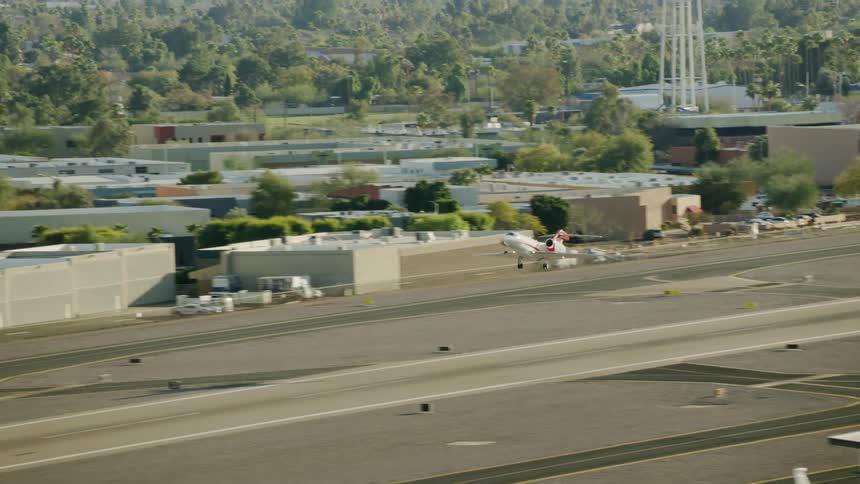 A commercial airplane takes off from a runway in a small airport