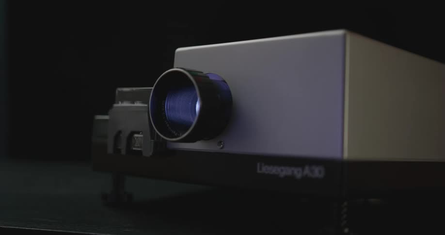 A slide projector illuminates slides as it advances through them automatically