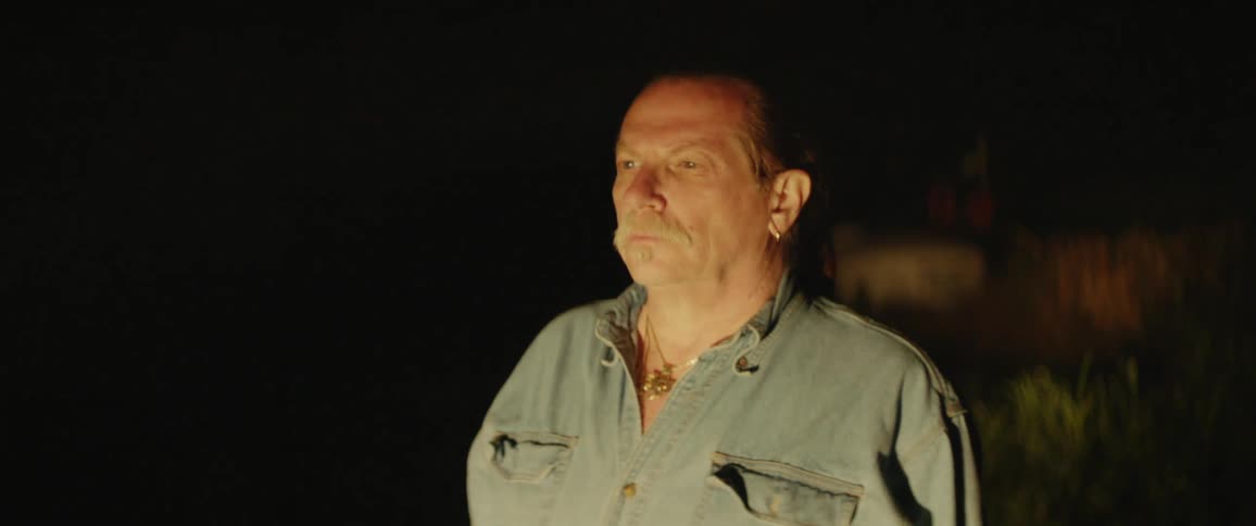 The man is staring into headlights at night