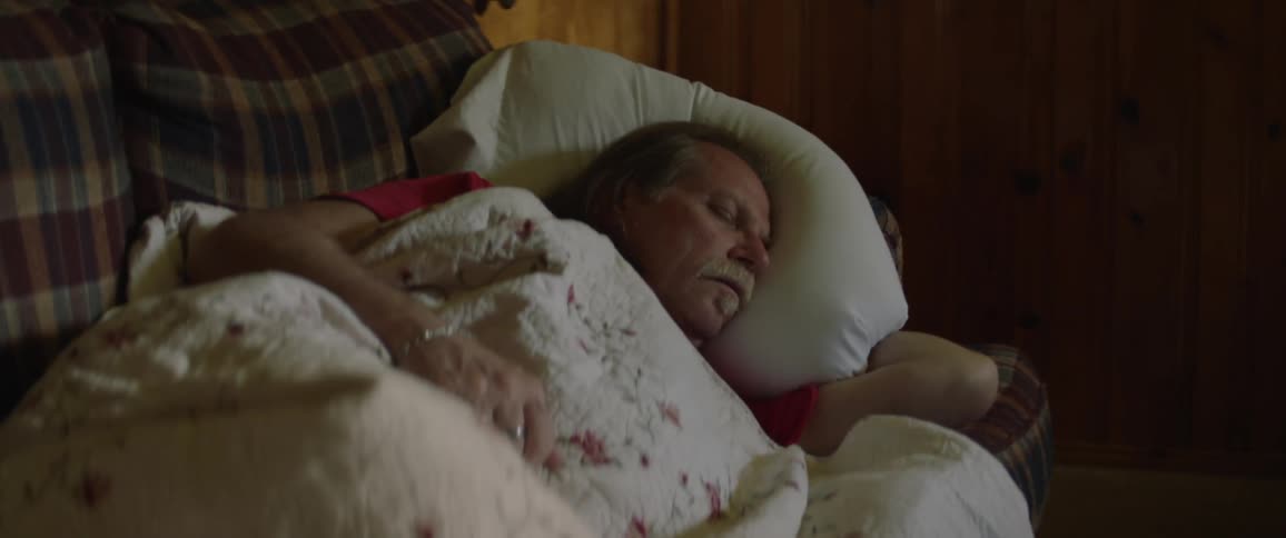 The man is sleeping on the couch