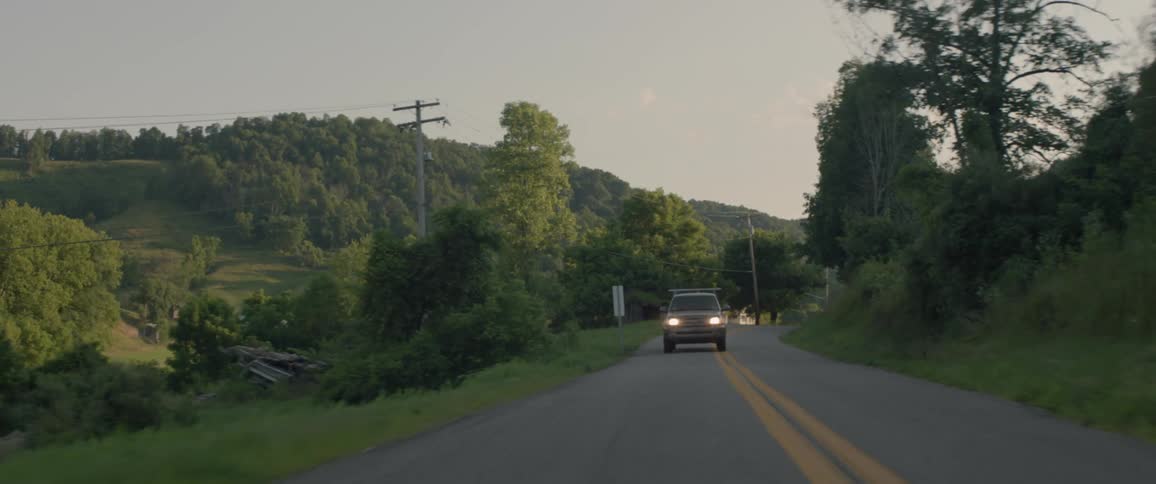 A vehicle travels on a rural road