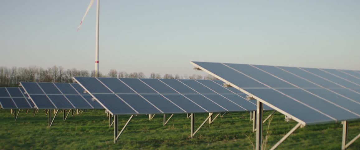 Solar panels and wind turbines in field