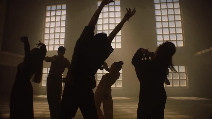 A group perform a choreographed dance in the studio