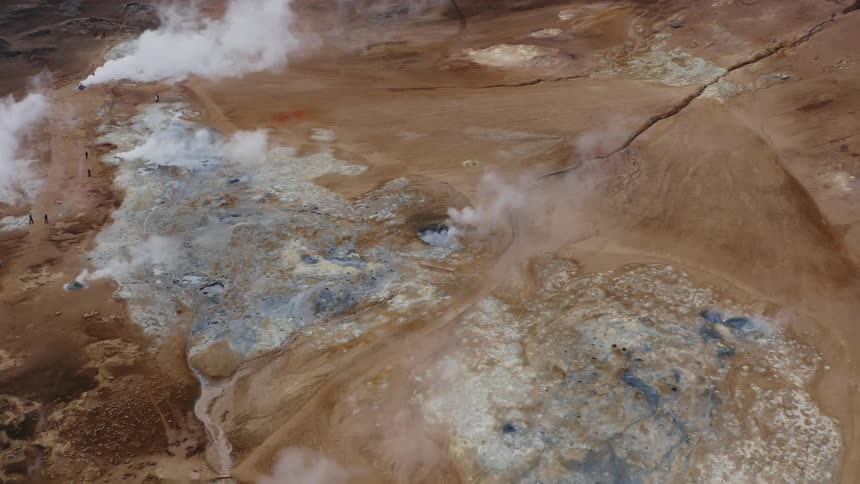 Aerial view of red clay earth with geothermal activity and mud pots maybe iceland