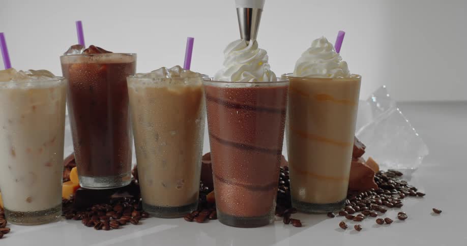 Applying whipped cream to a smoothie on display