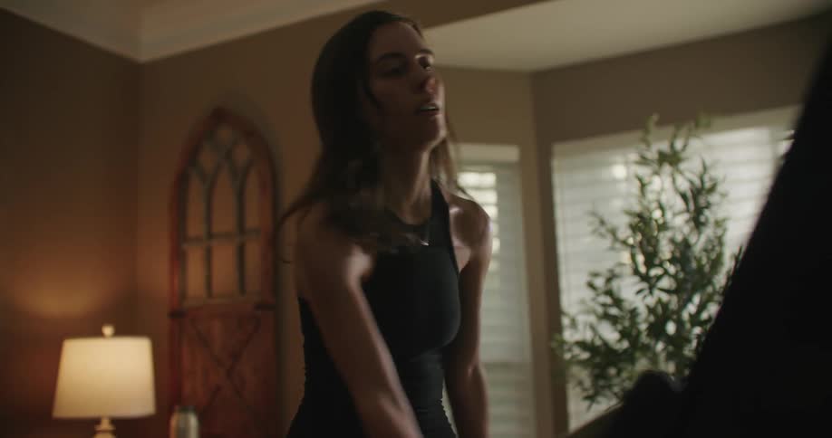 A woman is working out on an exercise bike in her home