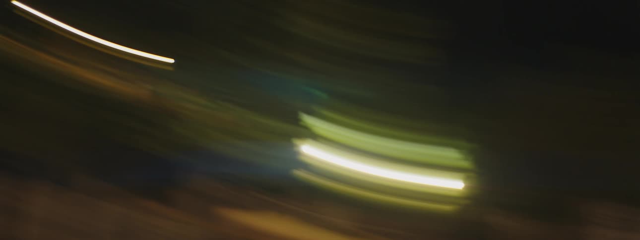 Rapid movement creates streaks from lights and trees