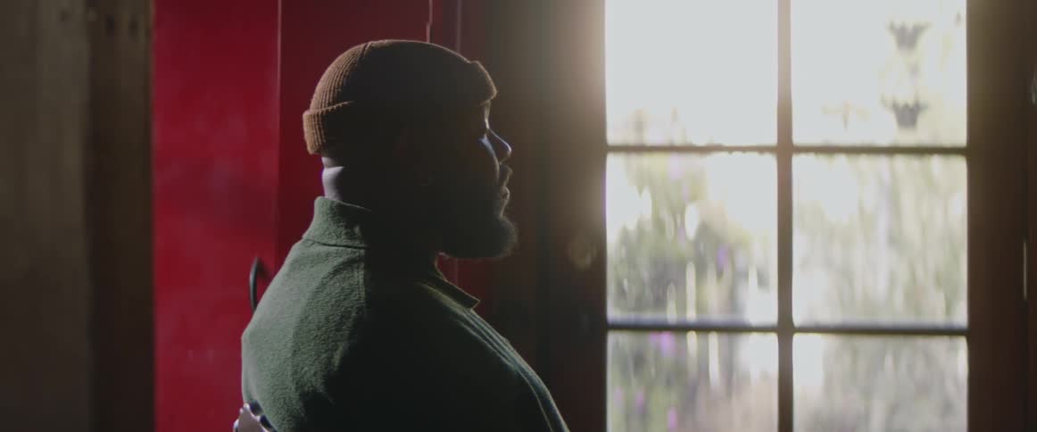 A man turns his head to look out the window