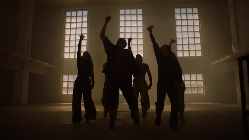 People dancing in a dark hall the atmosphere is illuminated by the energy of their movements synchronized to the rhythm of the music