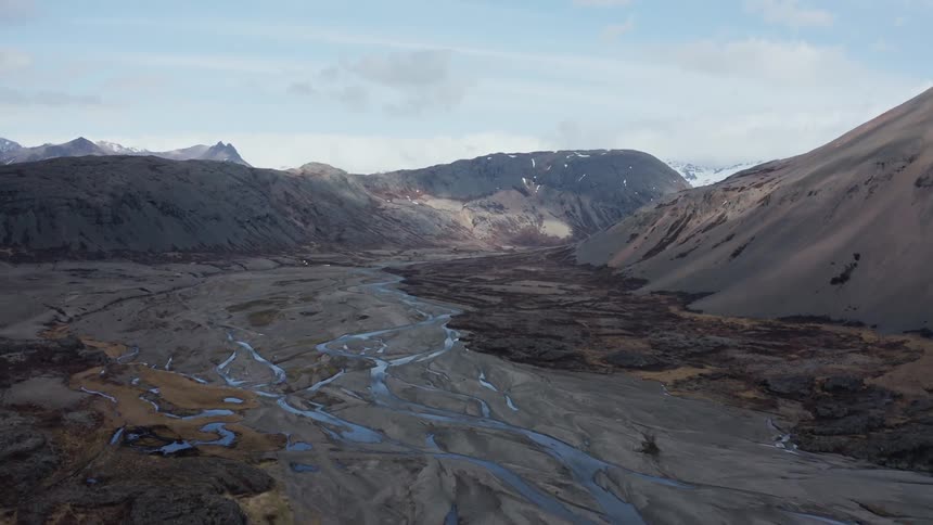 Aerial view of mountains canyons and streams on a partly cloudy day