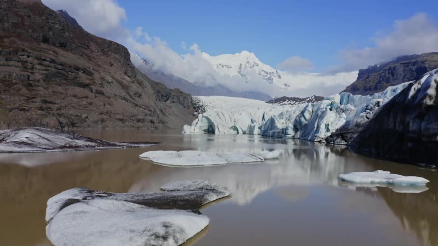 Landscape of big ice fragments floating glazier and snowy mountain