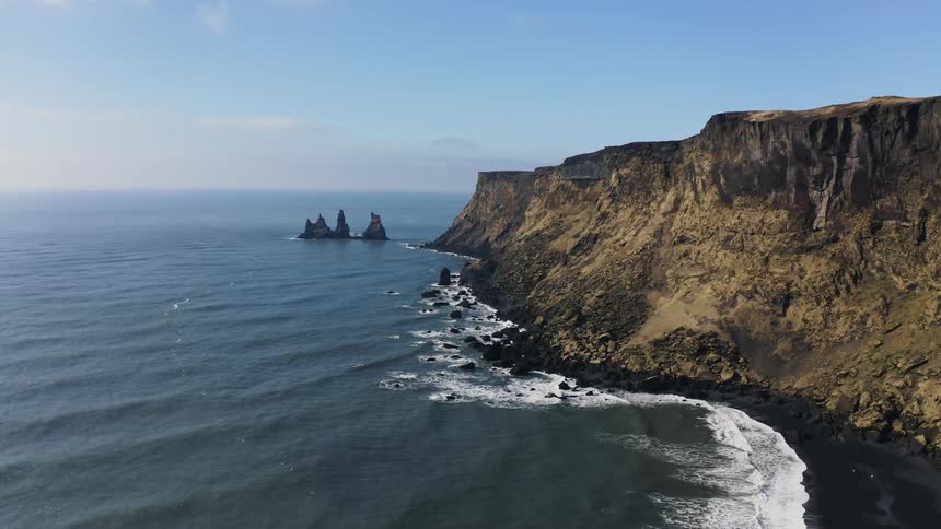 Aerial view of coastal cliffs on the coast next to the ocean at daytime