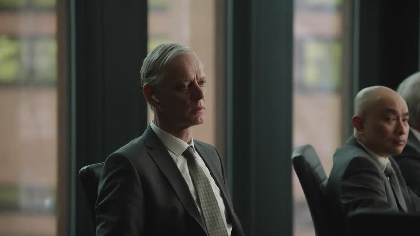 A man is wearing earbuds not listening at a meeting
