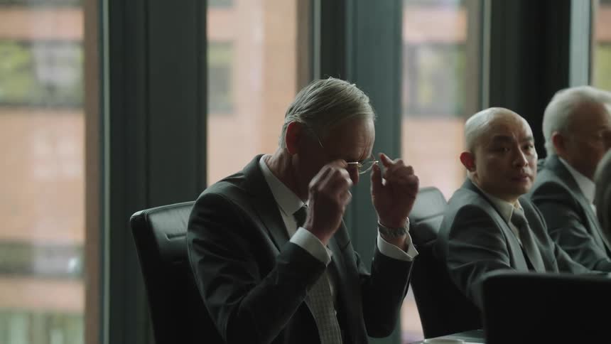 Business takes off earbuds to attends a board meeting in the office