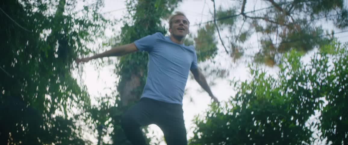 A man is jumping high on a trampoline