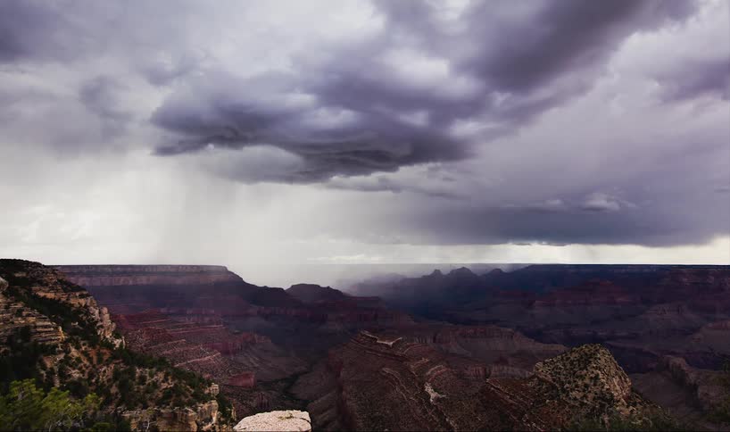 Clouds roll over a large canyon