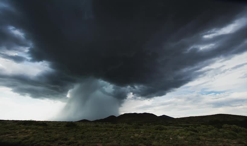 A storm builds above a train track
