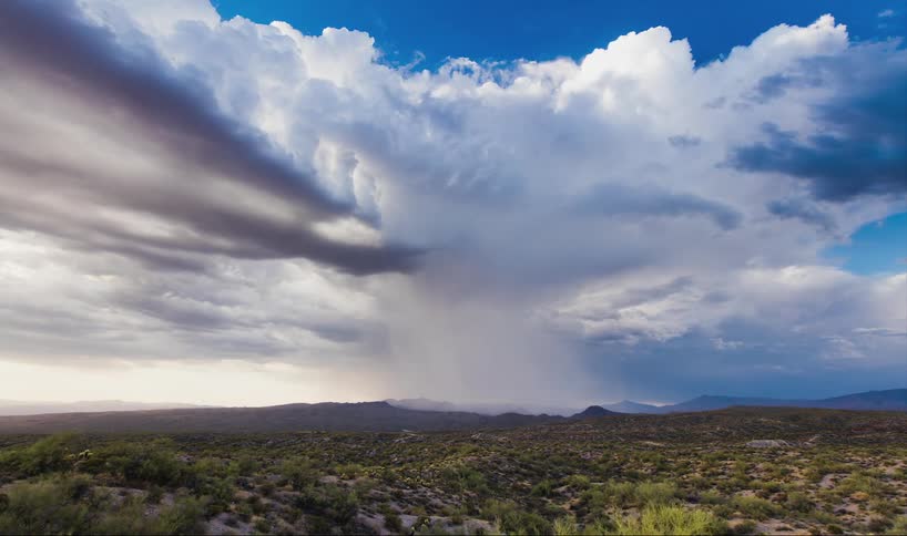 Time lapse of clouds moving over a hilly field pouring rain