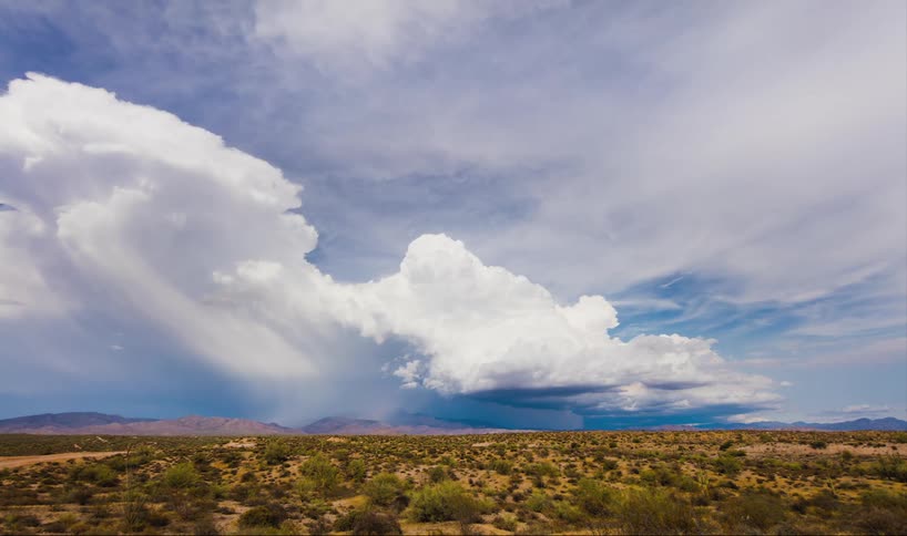 Time lapse of clouds moving and pouring rain in the distance