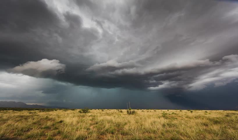 Time-lapse of storm clouds moving over a grassy area