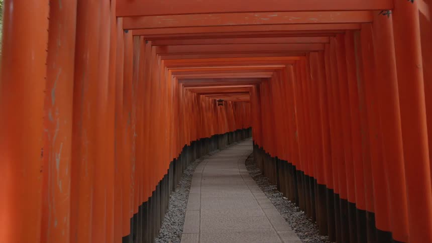 Tunnel leading through structure of red and black posts