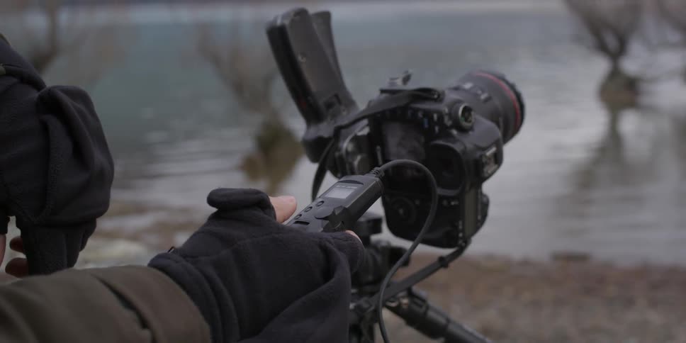 A person presses a button to operate a camera